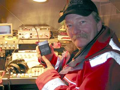 Man in red jacket holds Lectrosonics transmitter near Law & Order SVU equipment