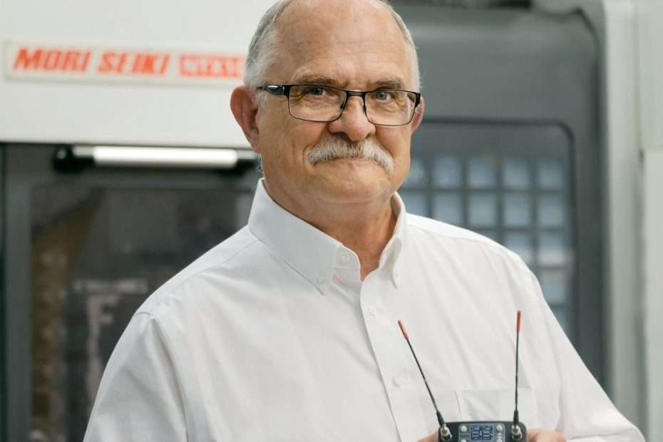 Gordon Moore, Chairman of the Board at Lectrosonics, holding wireless equipment.