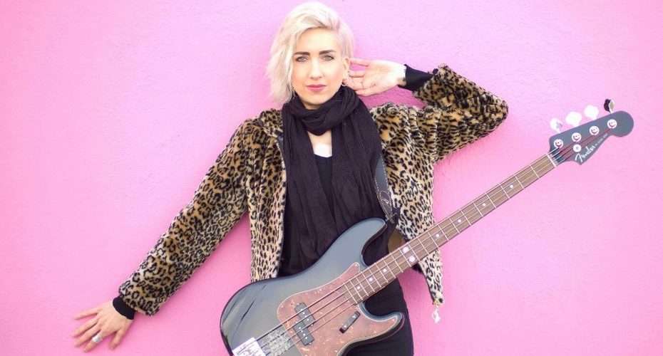Bass guitarist with blonde hair and leopard print jacket at NAMM 2020