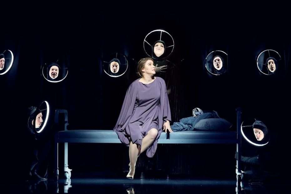 Santa Fe Opera's 'Orfeo' production features a soprano on a bed with masked figures.