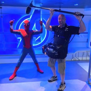 Greg Murphy with Spiderman, holding a boom mic, possibly for a podcast or video