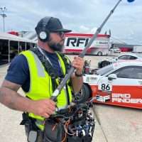 High-Five-Sound-and-Lectrosonics2 Sound engineer with boom pole and gear at a race track, featuring Lectrosonics