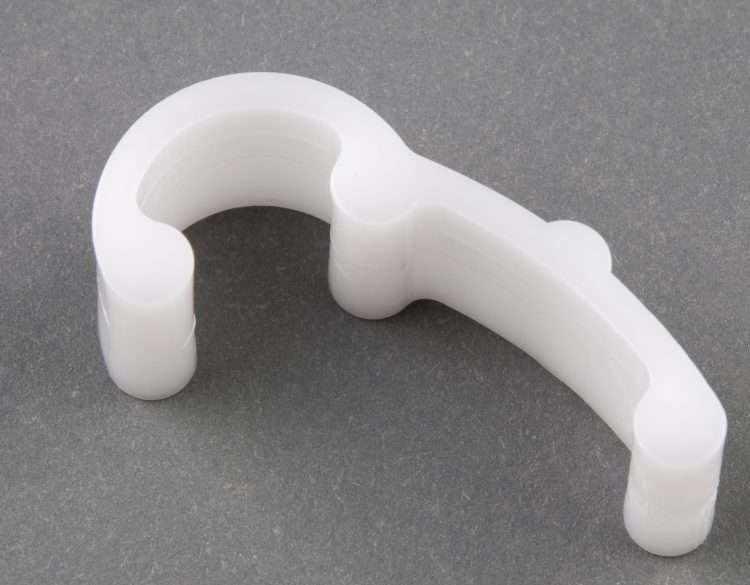 White plastic P1196 part with a curved hook shape and two cylindrical feet