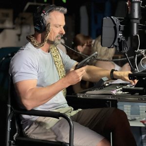 Paul Hunt with a snake around his neck, working with Lectrosonics wireless gear.