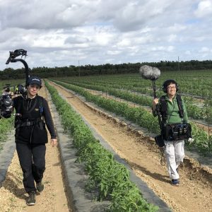 Shuling-Yong2 Filmmakers with camera and sound gear in a field, capturing stories of social change.