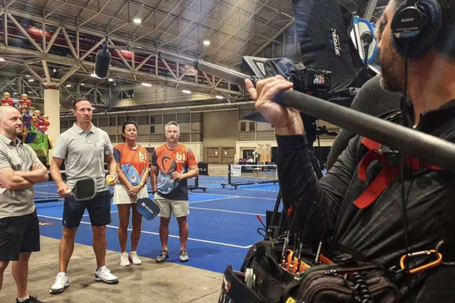 Eric Ledet and others at a pickleball event, with a videographer filming.